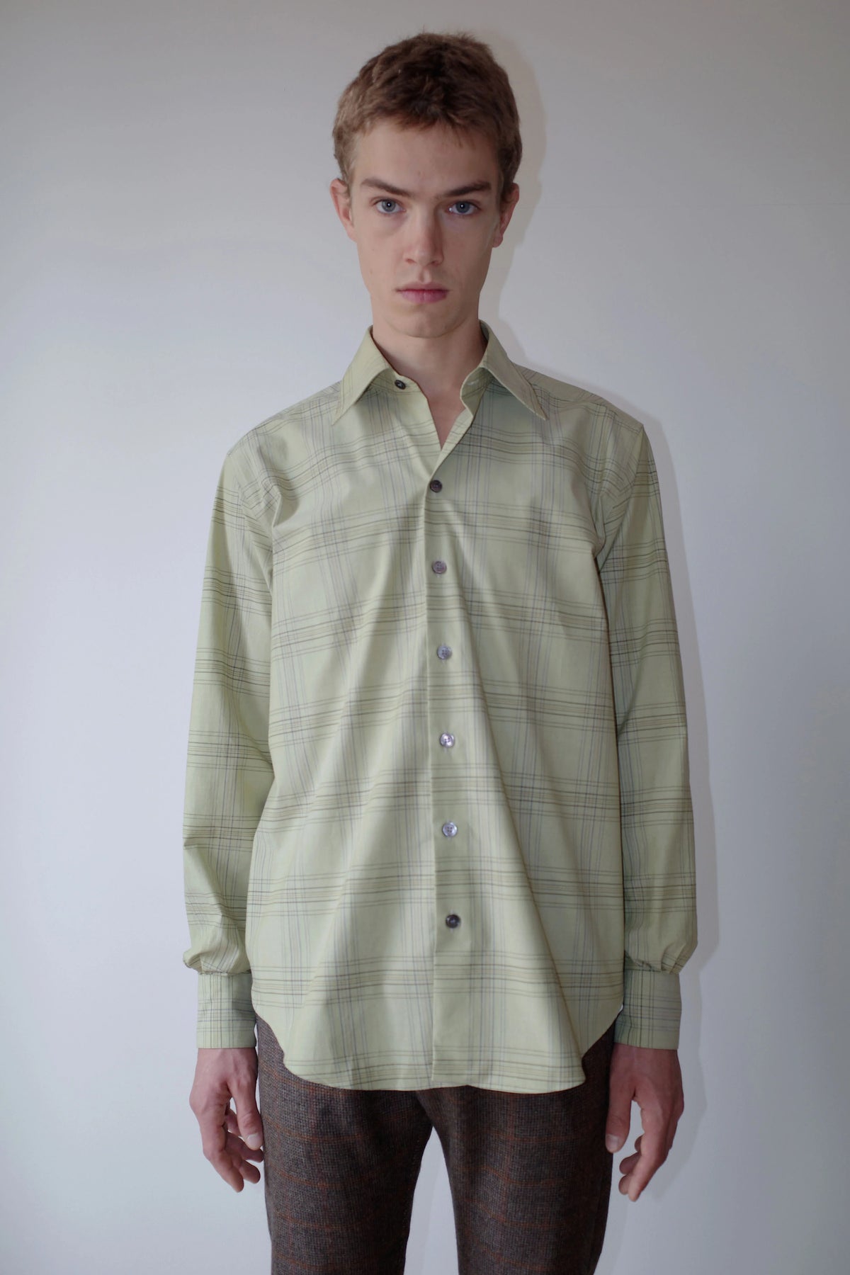 CAMISAS MANOLO（カミサス マノロ）Normal Shirt Pale Green Blue Checksの正面着用画像。淡いグリーンをベースにブルーのチェック柄を配した長袖シャツ。リラックスしたシルエットとラウンドヘムが特徴。