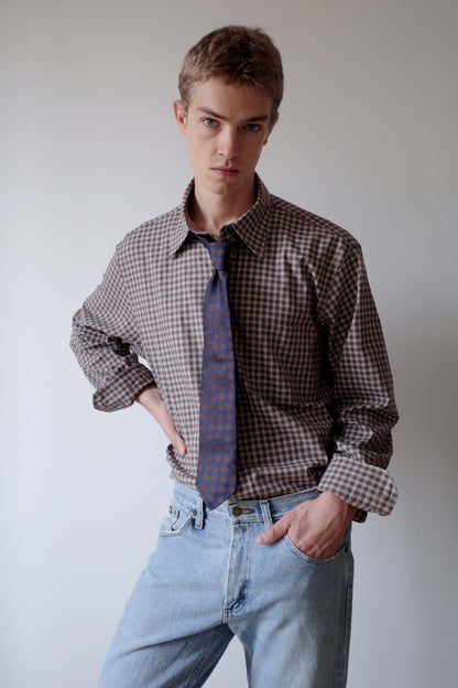 CAMISAS MANOLO（カミサス マノロ）Campo Shirt Brown/Camel Checksのスタイリング画像。ブラウンとキャメルのチェックシャツに柄物のネクタイとライトブルーのデニムを合わせた着用スタイル。袖をまくり、裾をタックインしたコーディネート。
