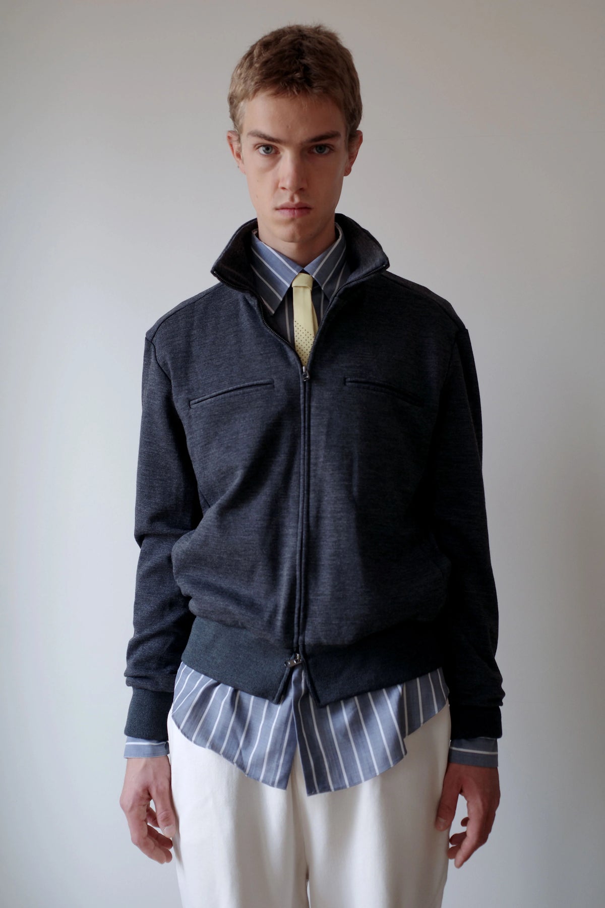 CAMISAS MANOLO（カミサス マノロ）Jersey CM Jacket Greyの正面着用画像。落ち着いたグレーのウールジャージー素材を使用したジップジャケット。スタンドカラーと左右の胸ポケット、裾と袖口のリブ切り替えが特徴。