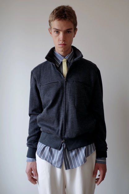 CAMISAS MANOLO（カミサス マノロ）Jersey CM Jacket Greyの正面着用画像。落ち着いたグレーのウールジャージー素材を使用したジップジャケット。スタンドカラーと左右の胸ポケット、裾と袖口のリブ切り替えが特徴。