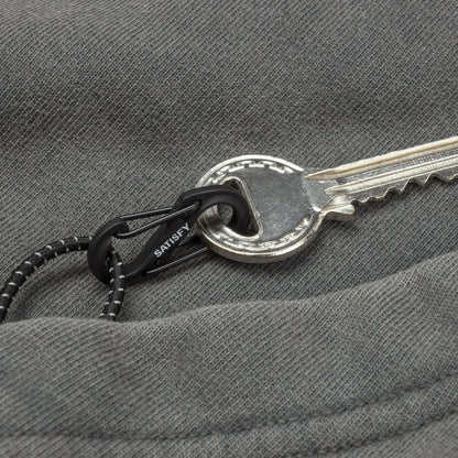 SATISFY MothTech™ Hoodie Faded Blackのポケットディテール。カンガルーポケットに備えられたミニS字カラビナ。