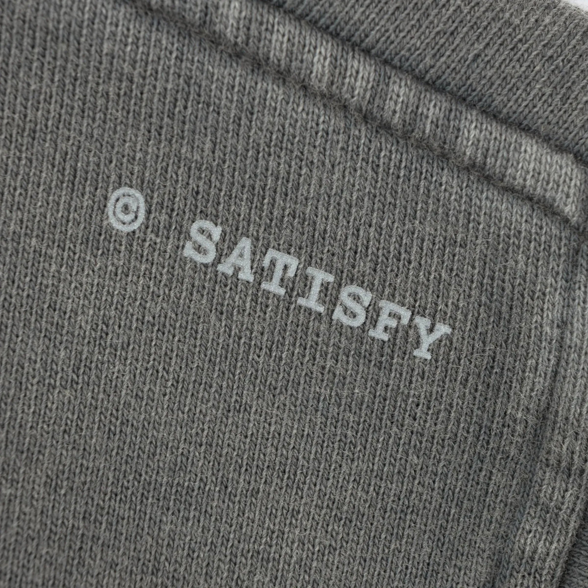 SATISFY MothTech™ Hoodie Faded Blackのロゴディテール。ウォッシュ加工されたコットン生地に配置された©SATISFYロゴ。
