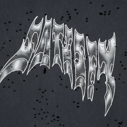SATISFY MothTech™ T-Shirt Aged Black AirBrush Glitterのロゴディテール。牙のようにアレンジされたグリッタープリントとMothTech™の通気孔。